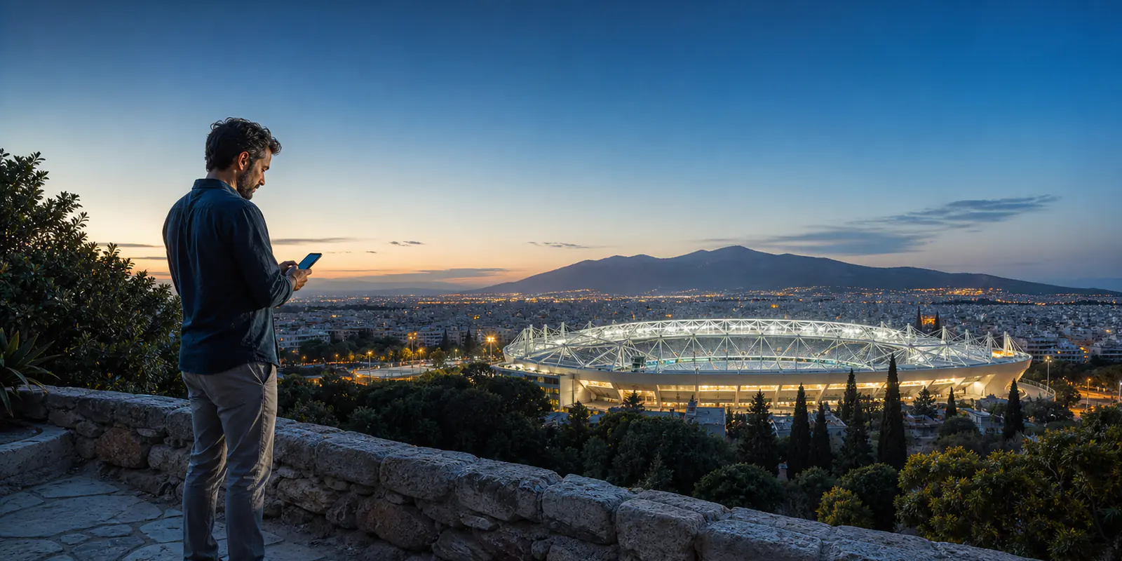 Έλληνας φίλαθλος χρησιμοποιεί εφαρμογή κατά τη διάρκεια νυχτερινού αγώνα
